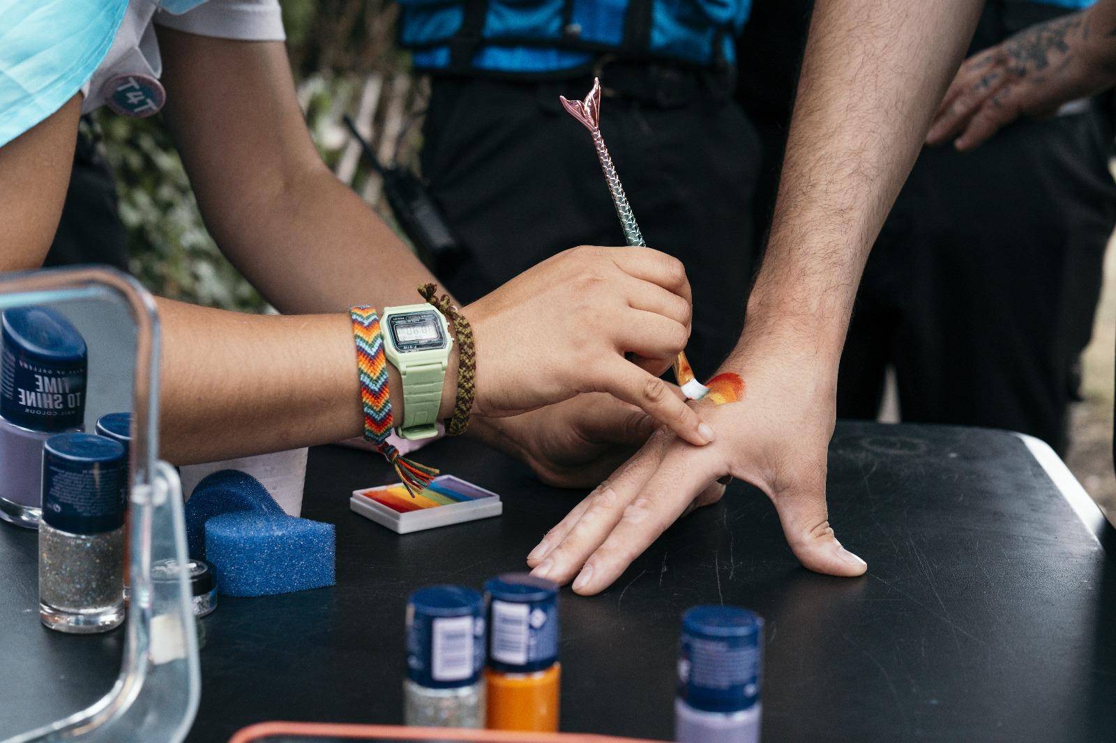 Close-up of rainbow face paint being applied at the Bath Pride event under security cover